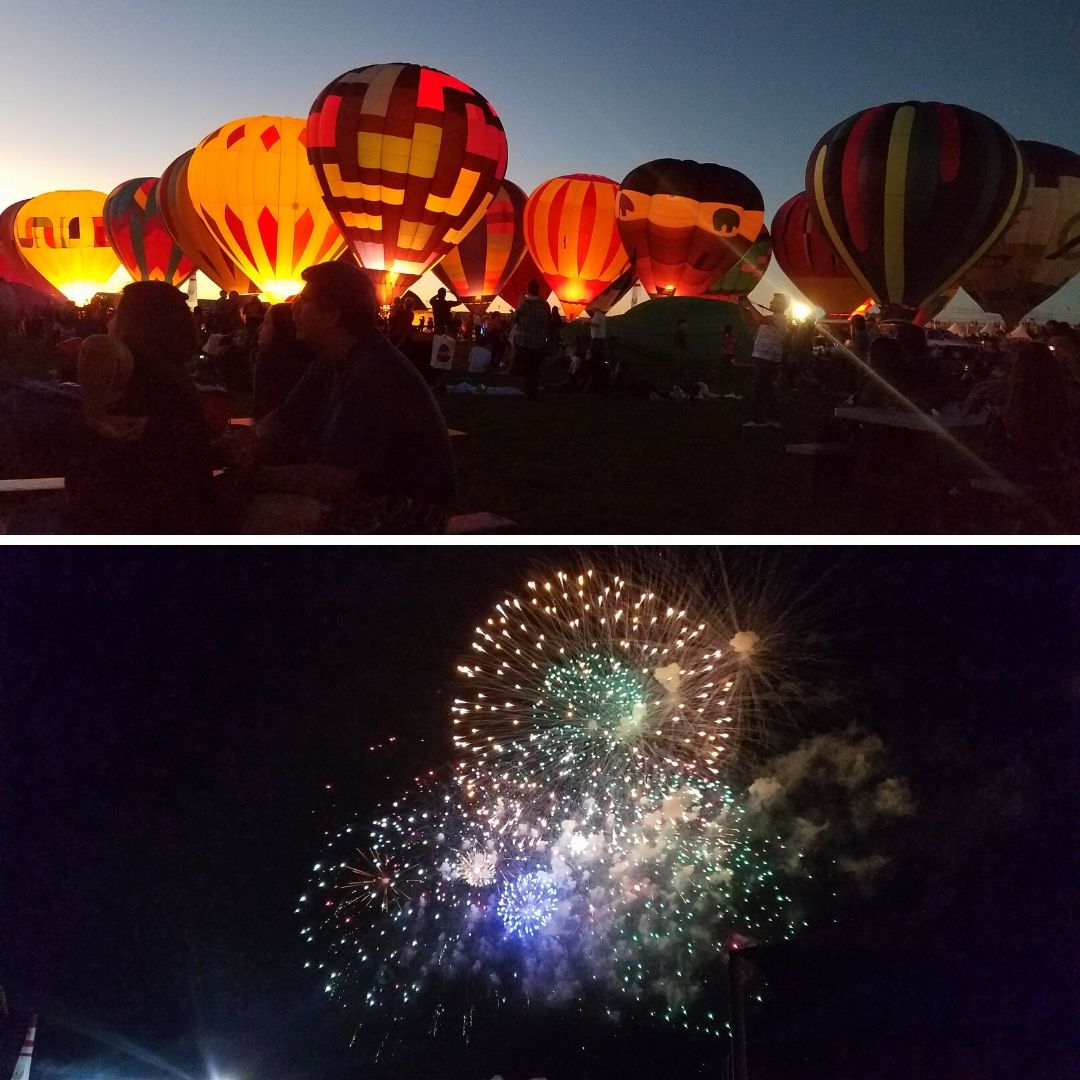 Multiple hot air balloons light up at dusk and a round of fireworks exploding against the night sky