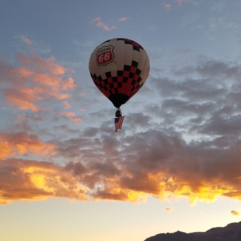 Hot air balloon carries the US Flag across the morning sky