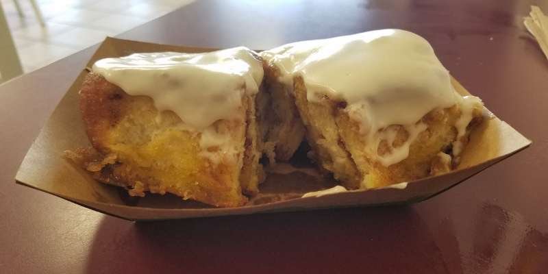 Large cinnamon roll slathered in cream cheese frosting.